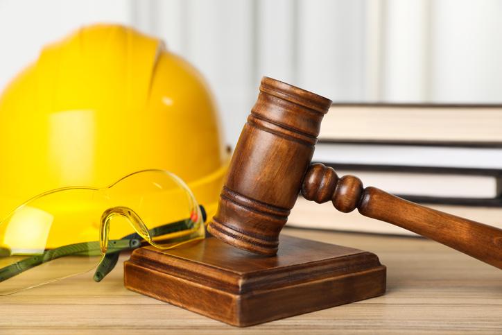 Gavel beside safety helmet and glasses signifying workers compensation attorneys